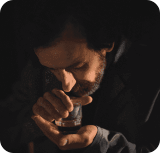 homem a cheirar o copo com o azeite